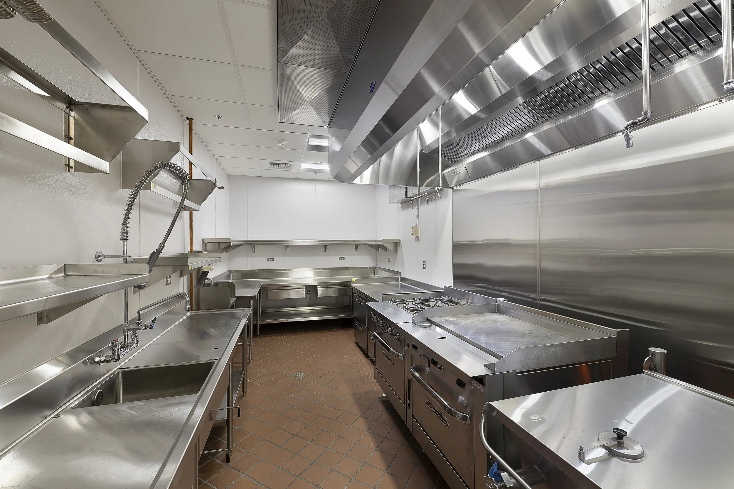 Stainless steel workstations and cooking equipment in a commercial kitchen